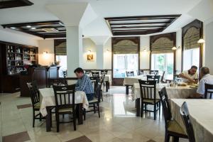 a man sitting at a table in a restaurant at Hotel President in Satu Mare