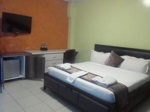 TROTTERS B&B KENOL في Gitura: غرفة نوم بسرير كبير عليها مناشف