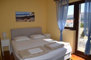 una camera da letto con un letto con asciugamani sopra di Apartments Aneva 1 a Baška