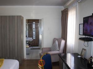 a hotel room with a bed and a chair at Lilitha Hotel-Butterworth in Butterworth