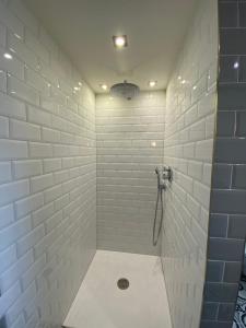ケムニッツにあるPension Gablenzの白いタイル張りの壁のバスルーム(シャワー付)