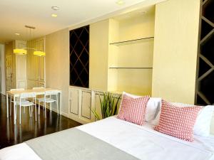a bedroom with a bed and a dining room at Grand Diamond Condominium in Bangkok