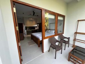 a room with a bedroom with a bed and a mirror at Cozy Corner - Midigama in Midigama
