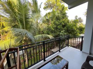 a balcony with a black railing and palm trees at Cozy Corner - Midigama in Midigama