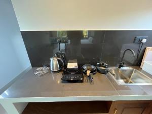 a kitchen counter with a stove and a sink at Cozy Corner - Midigama in Midigama