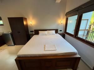 a bed in a room with a large window at Cozy Corner - Midigama in Midigama
