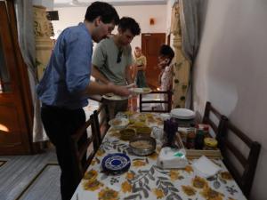 dos hombres parados alrededor de una mesa preparando comida en Vishal Villa, en Jaipur