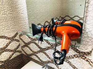 an orange hairdryer is hanging on a wall at Era Holiday House in Mirissa