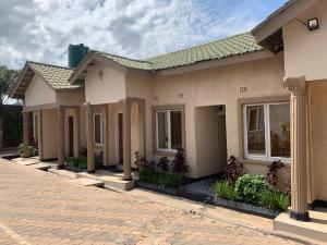 uma casa com uma estrada de tijolos em frente em JUBILEE EXECUTIVE LODGE em Lusaka