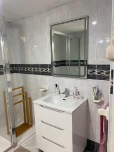 ein Badezimmer mit einem weißen Waschbecken und einem Spiegel in der Unterkunft Mirador del Puerto in Aguadulce + 26 Fotos