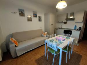 a living room with a couch and a table with chairs at La Casa dei Cipressi in Belluno