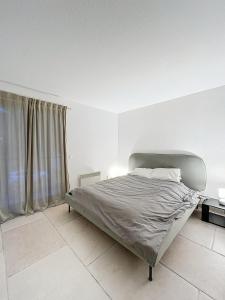 Bett in einem weißen Schlafzimmer mit Fenster in der Unterkunft Luxurious 3 Rooms, Pool, Bnbrickeys in Beausoleil