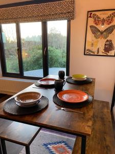 un tavolo in legno con piatti e una finestra di Holly's Lodge a Wellington