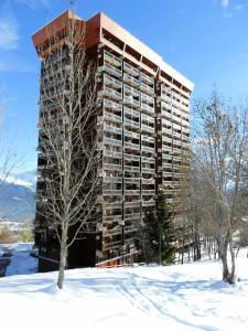 een hoog appartementencomplex in de sneeuw met bomen bij Résidence Lunik - 2 Pièces pour 5 Personnes 404 in Le Corbier