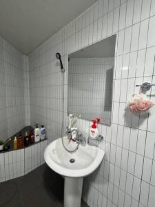 Baño blanco con lavabo y espejo en Homey inn Juno, en Suwon