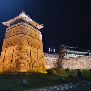 un gran edificio de ladrillo con un castillo por la noche en Homey inn Juno, en Suwon