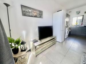 ein Wohnzimmer mit einem TV und einem Kühlschrank in der Unterkunft 83/3-Lovely 1 Bedroom Penthouse in Birkirkara