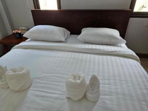 twee paar slippers op een wit bed bij Aonang Peace Pool Villa in Ban Khlong Haeng
