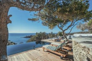 una terraza con bancos y vistas al océano. en Zen Blue Mills, en Koundouros