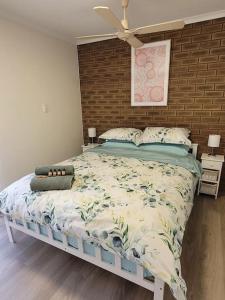 1 cama grande en un dormitorio con pared de ladrillo en The Sturt Stay, en Mulwala