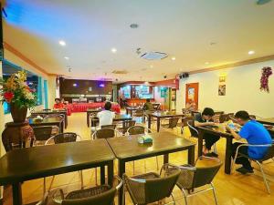 un gruppo di persone seduti ai tavoli in un ristorante di GRAND FAR EAST HOTEL SDN BHD a Masai