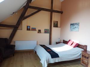 1 dormitorio con 1 cama y 1 silla en Ferienhaus Ferienscheune Kümmernitztal en Grabow