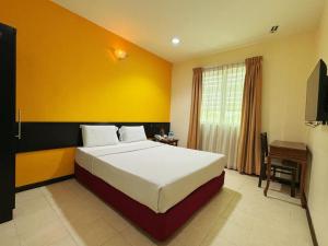 a bedroom with a bed and a yellow wall at GRAND FAR EAST HOTEL SDN BHD in Masai +13 photos