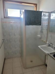 een badkamer met een douche en een wastafel bij The Sturt Stay in Mulwala