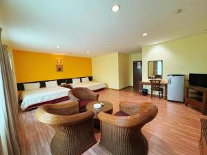 a hotel room with a bed and tables and chairs at GRAND FAR EAST HOTEL SDN BHD in Masai