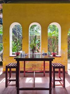 a table in a room with three windows at Bird House Mirissa in Mirissa