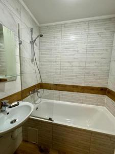 een badkamer met een bad en een wastafel bij Вірменська 12 in Lviv