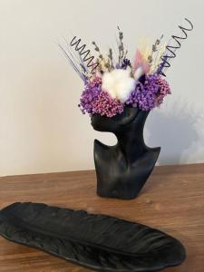 リヴィウにあるВірменська 12のテーブルの上に花の入った黒い花瓶