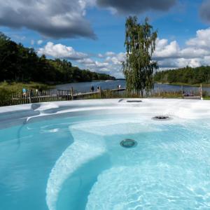 a hot tub with a view of the water at Skeviks Gård in Gustavsberg