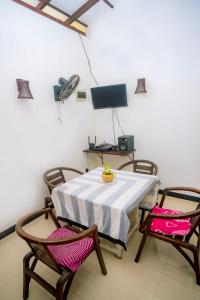 a room with a table and two chairs and a television at Sajini Villa in Weligama