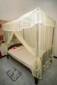 a bed with a canopy in a room at Sajini Villa in Weligama