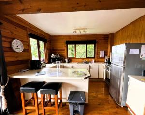 a kitchen with a counter with stools and a refrigerator at Muri Vista Villas in Muri