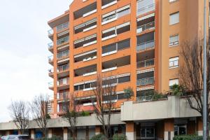 un immeuble d'appartements oranger avec des arbres devant lui dans l'établissement Bright Apartment with balcony and terrace, à Milan