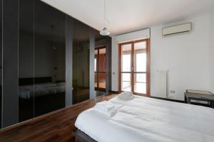 - une chambre avec un grand lit blanc et un miroir dans l'établissement Bright Apartment with balcony and terrace, à Milan