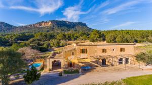 an old stone house with a mountain in the background at Villa Son Pons by Slow Villas in Llucmajor