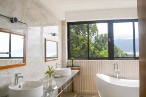 un bagno con due lavandini e ampie finestre di Sunbird Villas a Glacis