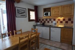 une cuisine avec une table en bois et une salle à manger dans l'établissement Résidence Cristallines - 3 pièces 6 personnes MAE-4424, à Orcières