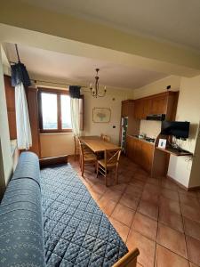 ein Wohnzimmer mit einem Tisch und einer Küche in der Unterkunft Residenza Vallefiorita in Rocchetta a Volturno