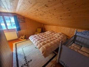 a bedroom with a bed in a wooden room at Mimöseli in Schwarzsee
