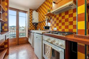 a kitchen with a stove top oven next to a window at Encantador loft in Sant Sadurní dʼAnoia