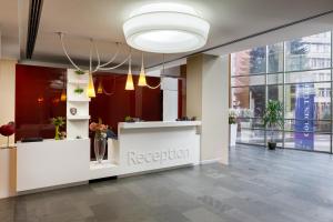 a reception area in a lobby with a reception counter at Hotel Golden Tulip Ana Tower Sibiu in Sibiu