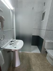 uma casa de banho com um lavatório, um chuveiro e um WC. em Hostal Horizonte em San Antonio