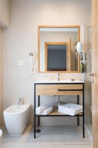 a bathroom with a sink and a toilet and a mirror at Hotel Parking Miradoiro de Belvís in Santiago de Compostela