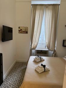 um quarto com uma cama com toalhas em La Dimora Di Teresa em Lanciano