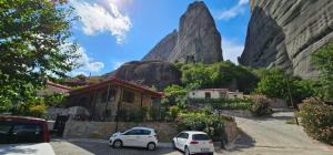 two cars parked in a parking lot in front of a mountain at Voulas Traditional House Meteora 3 in Kalabaka +19 photos
