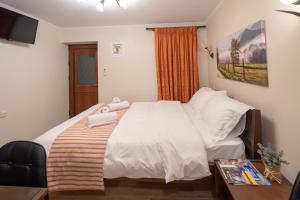 a bedroom with a large white bed and a table at Voulas Traditional House Meteora 3 in Kalabaka